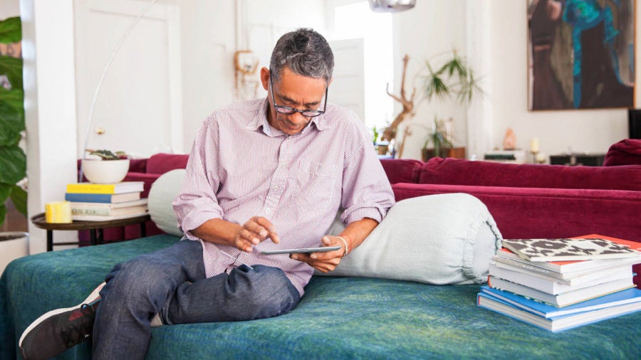 Man sitting on couch using tablet