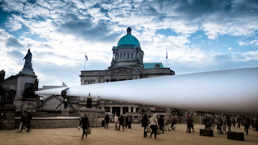 Siemens wind turbine blade in front of domed building clouds in sky