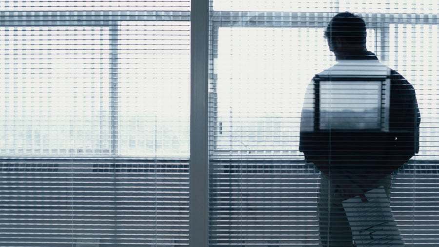 Man by window with blinds