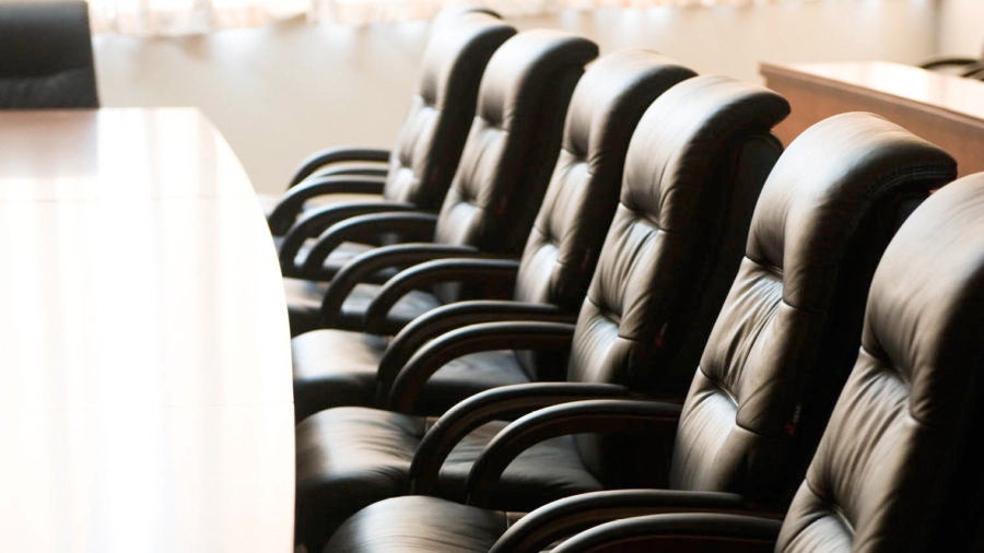 black office chairs facing a long desk