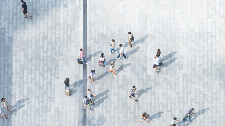 Bird's eye view picture of people walking on pavement