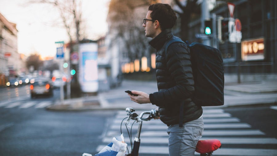 Man standing with bicycle holding phone