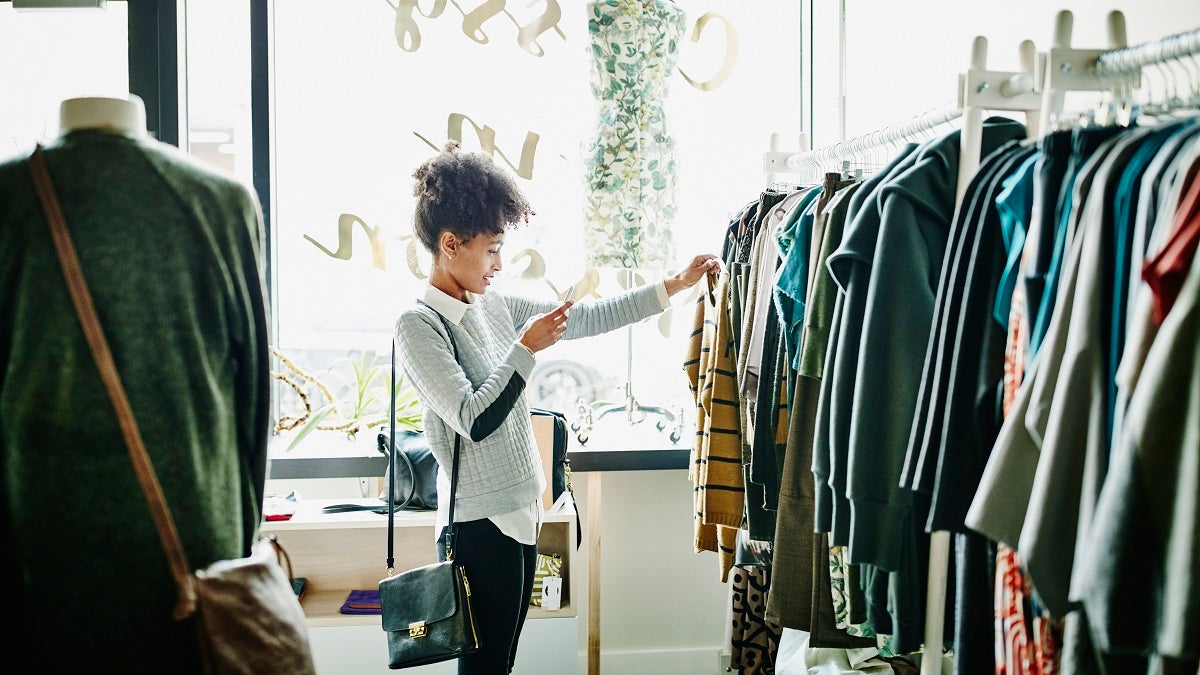 Women taking picture of clothing in shop