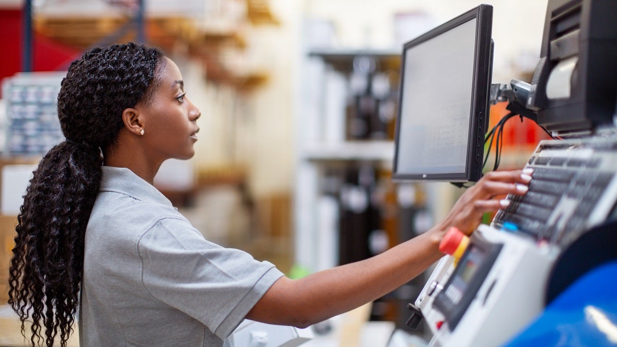 Female worker working on a machine in factory