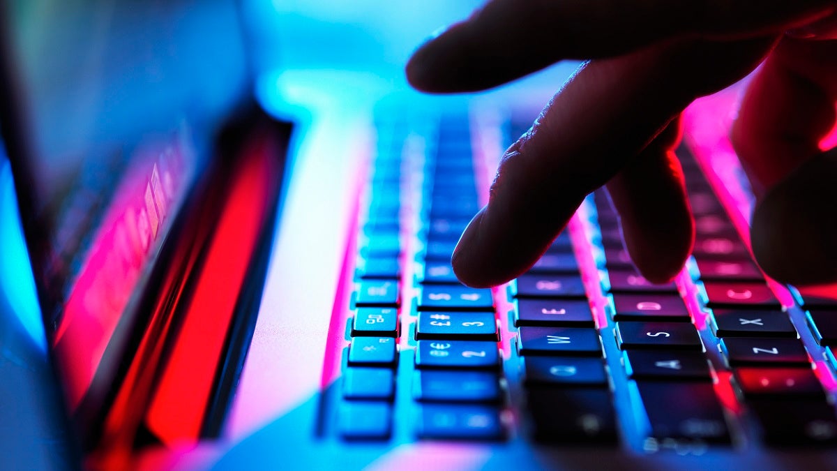 Man typing at his laptop computer at night