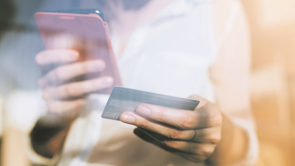 woman holding phone and credit card