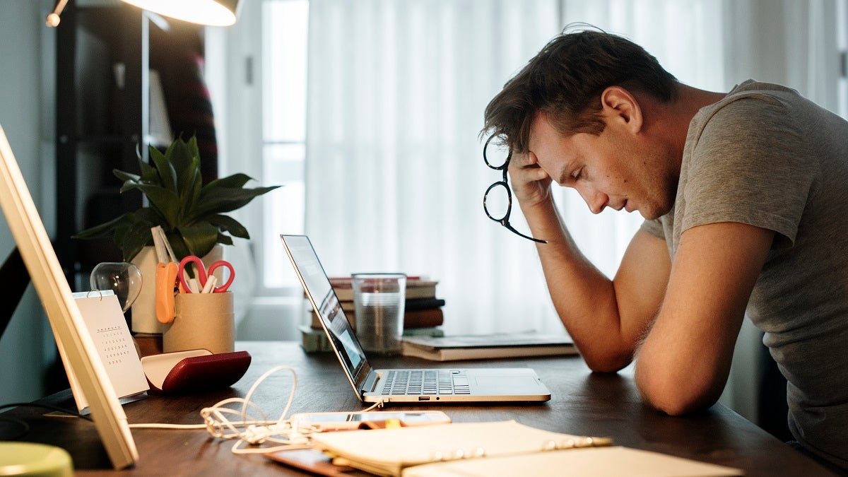 Man stressed while working on laptop