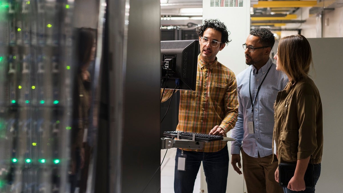 Technicians using computer in server room