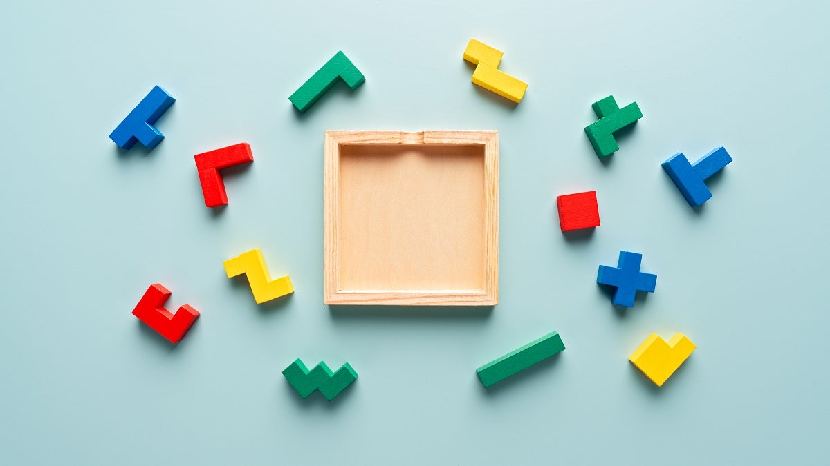 Pieces of Colorful Wooden Puzzle on Light Blue Colored Background.