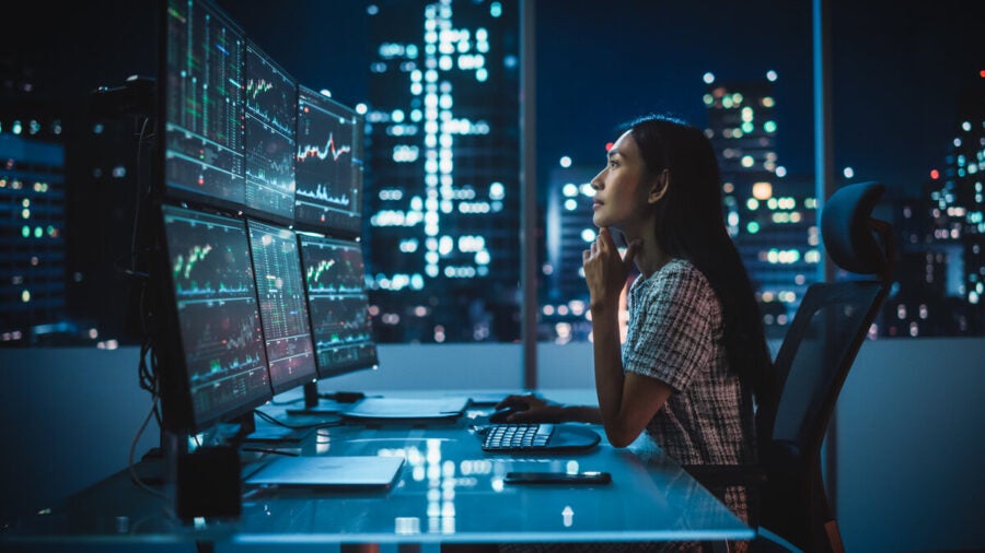 Woman working on large screens with data visualisation