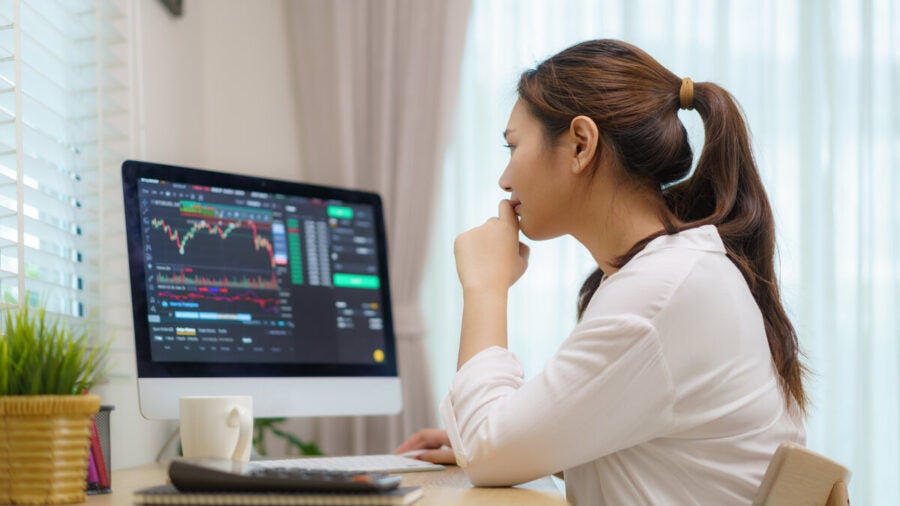 Young data analyst sitting at desk with computer