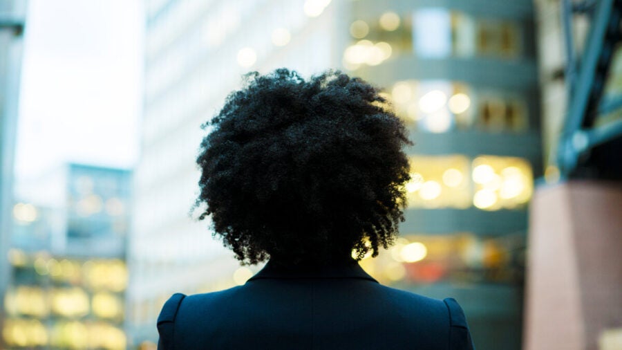 Businesswoman looks up at buildings, setting goals for the year ahead