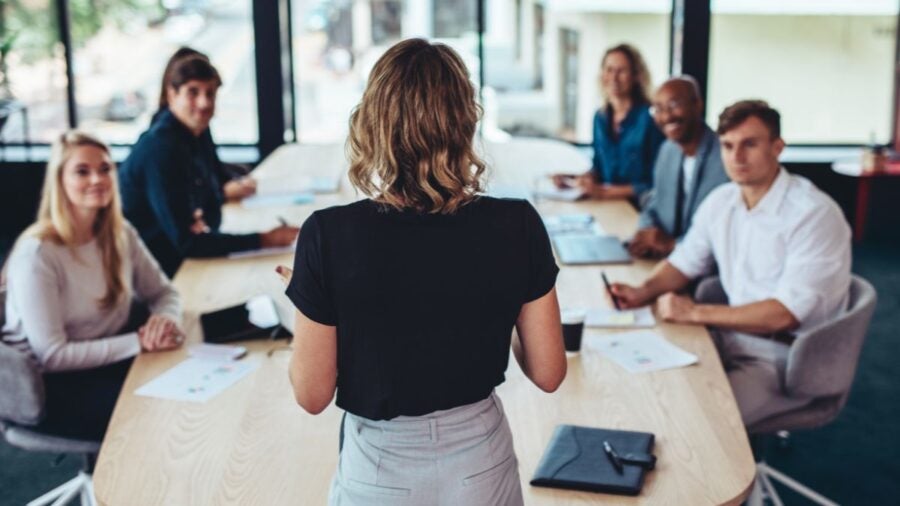 A middle manager leads a meeting with her team in an office