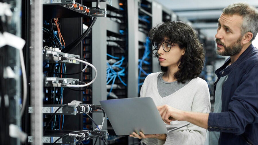 Technician discussing with coworker in server room