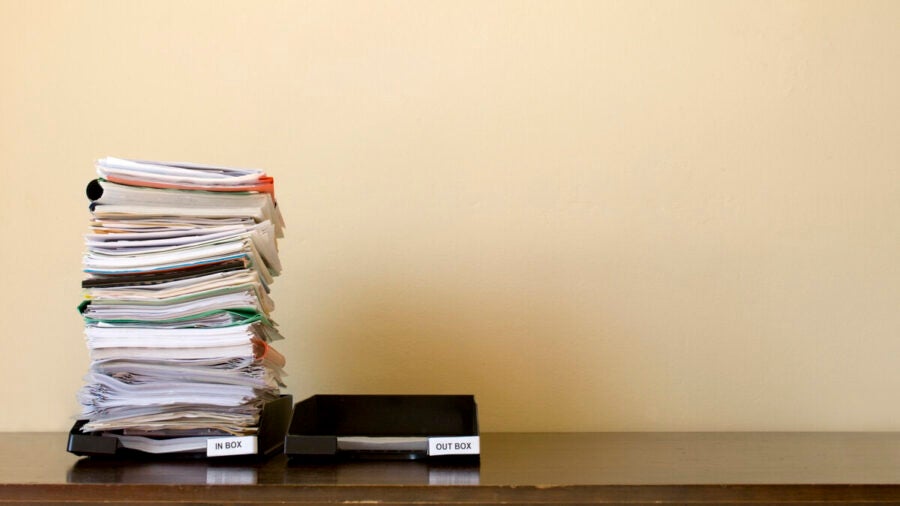 An inbox and outbox tray sit side by side; the inbox is full while the outbox is empty.