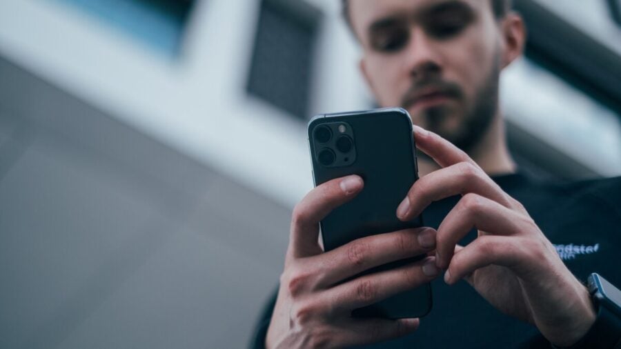 A low angle shot of a man, out of focus, using a mobile phone