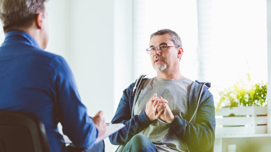 Mature Man Talking With Psychotherapist In His Office